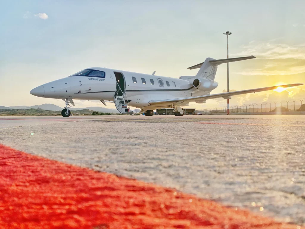 Pilatus PC-24 private jet on the tarmac at sunset