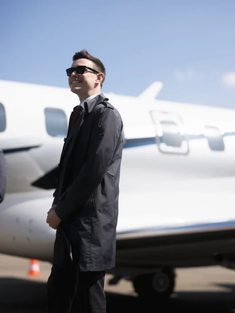 FLYINGGROUP pilot in a Butch Tailors uniform beside a private jet